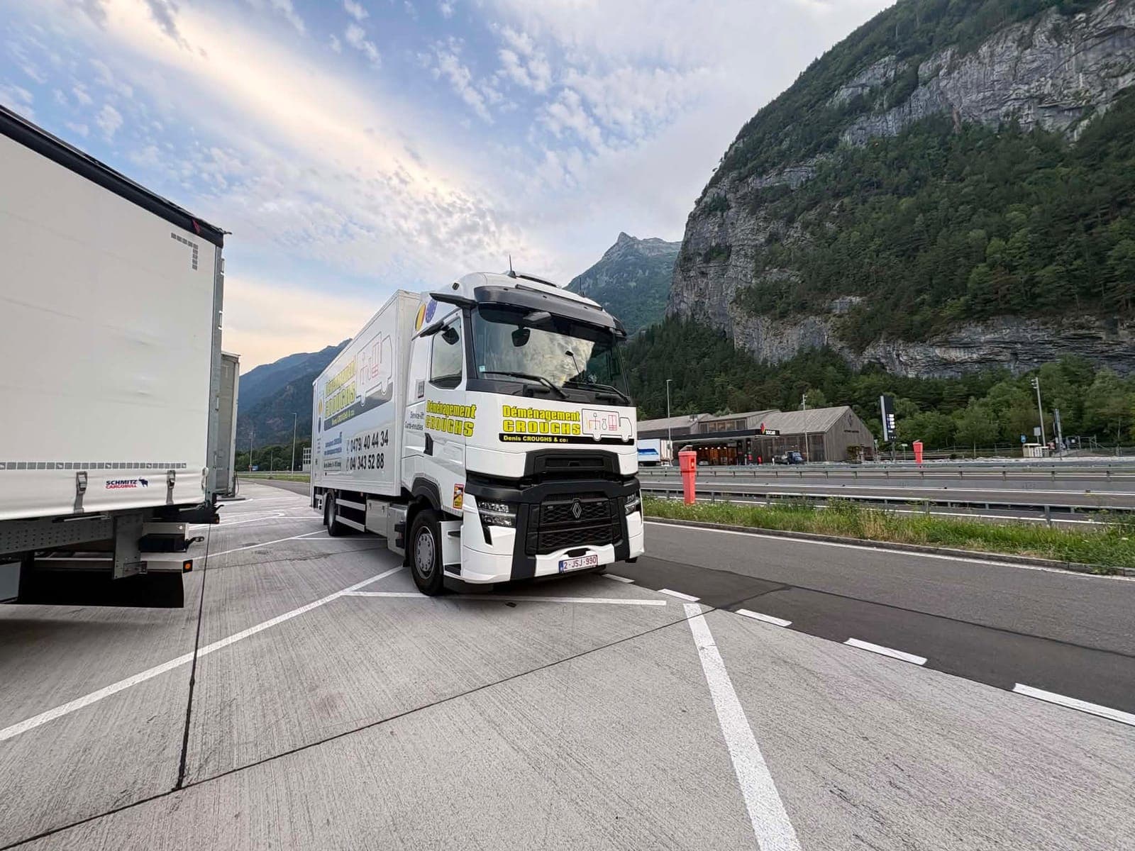 Camion Croughs Déménagement sur une aire d'autoroute au pied de hautes falaises de montagne
