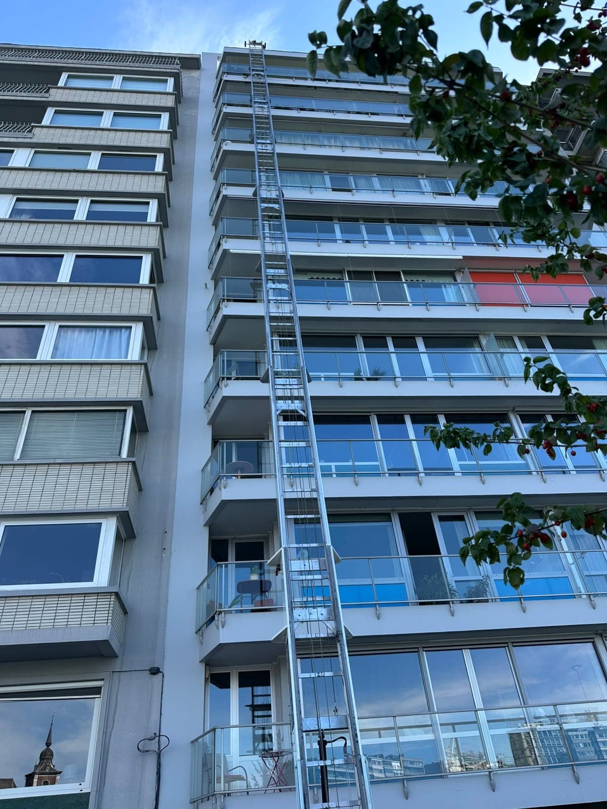 Échelle du monte-meubles Croughs dressée le long de la façade d'un immeuble à appartements jusqu'aux derniers étages