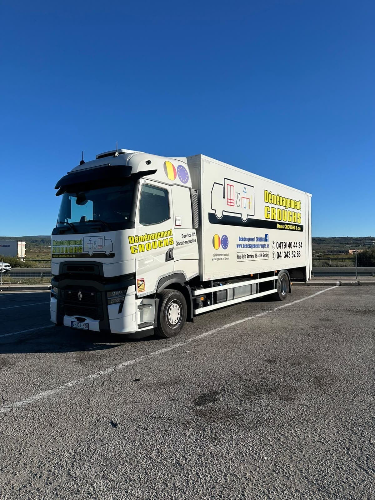Grand camion Croughs Déménagement à l'arrêt sur une aire de stationnement, sous un ciel bleu, collines à l'horizon